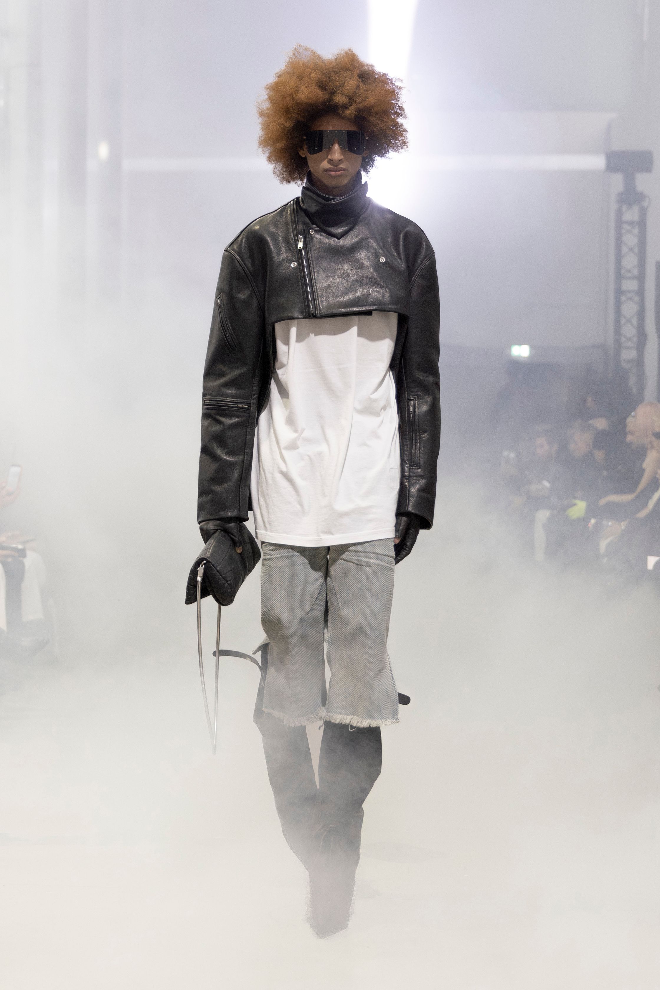 Rick Owens 2026秋冬延续其末世感与宗教式仪式美学。极端肩部结构、皮革与毛感材质在烟雾弥漫的空间中塑造出超越性别的强势身体。系列不再讨论日常，而是关于存在、力量与脆弱的对立统一。行走仿佛一种宣誓，服装成为精神铠甲，彰显Rick Owens一贯的黑暗崇高感-顽石频道趋势研究